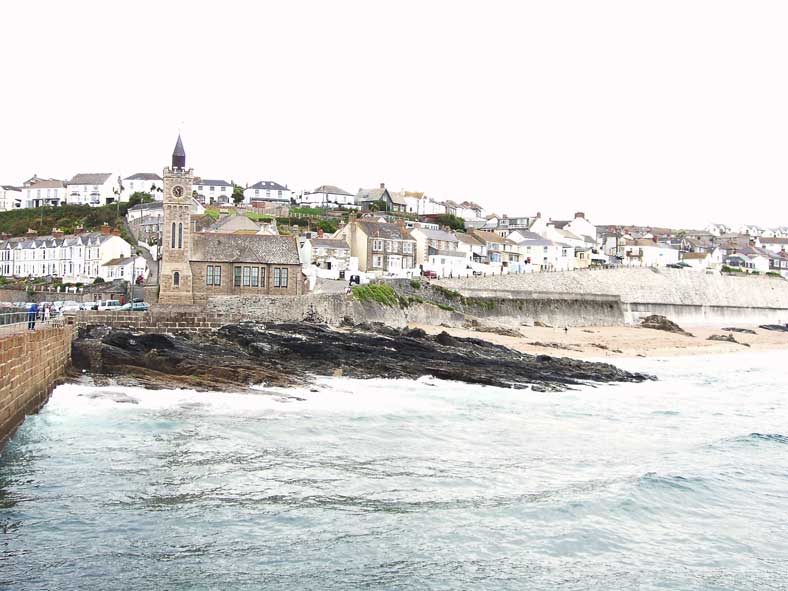 Selbst bei ruhiger See sch&auml;umen die Brecher gegen den Kapellenfelsen. Bei Sturm muss Porthleven furchterregend sein.